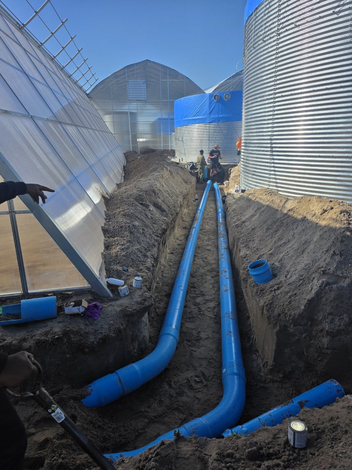 Excavator trenching in an agricultural field